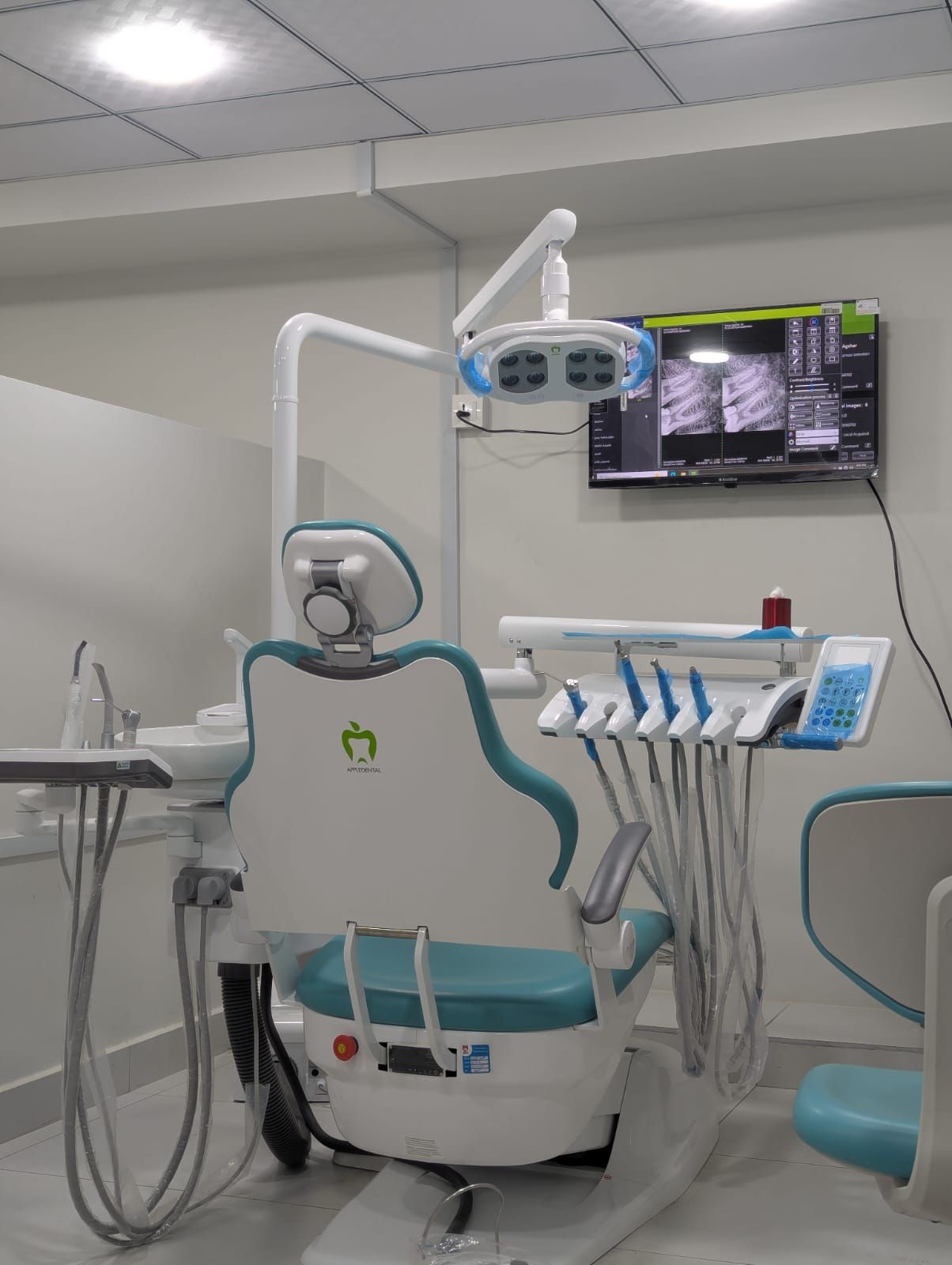 A treatment room at the North Nazimabad clinic, with a digital radiograph on the wall-mounted screen beside the chair